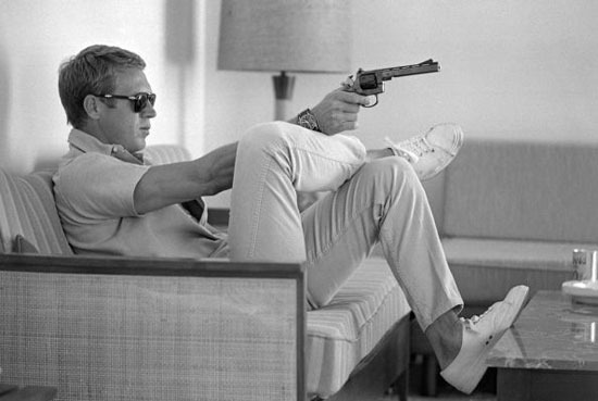 The King of Cool even looks cool threatening someone with a gun. Image from chasingstevemcqueen.tumblr.com